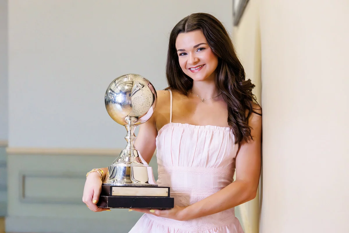 Irish dancer holding her championship trophy